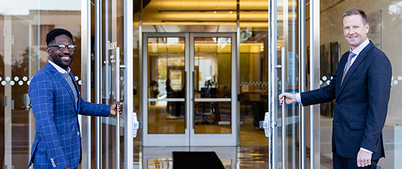Busey Associates, Jeremy Thorpe and Zach Hillard holding open Busey doors.