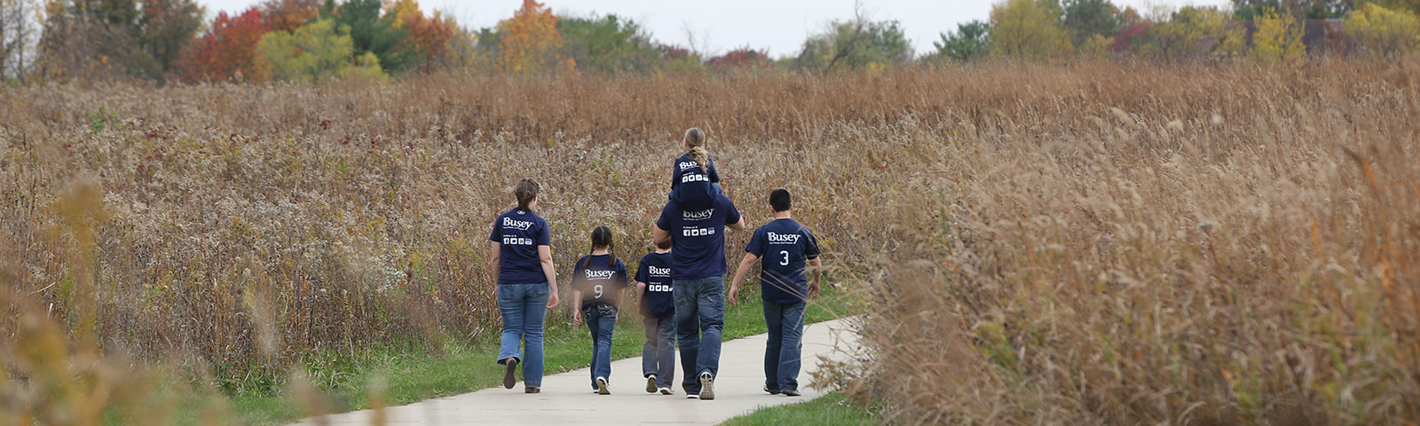 Volunteer family walking in a field.
