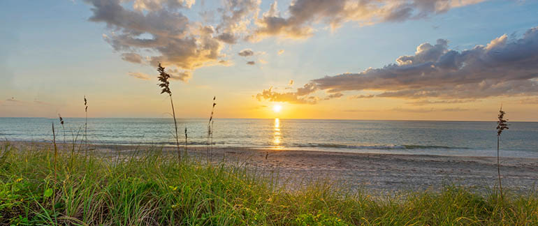 an ocean sunset across a beach