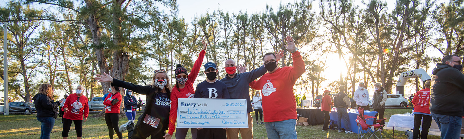 Busey Associates with a donation check