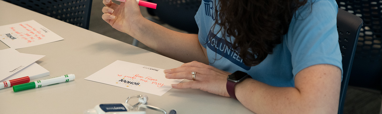 a Busey volunteer signing a card