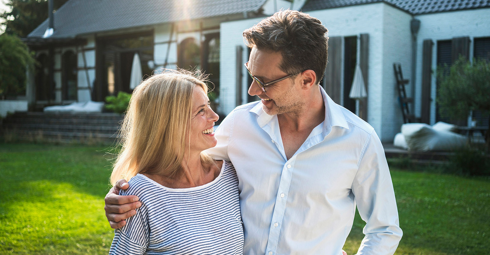 A couple looking at each other in front of a house