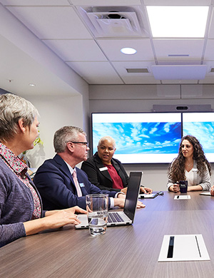 Busey associates around a meeting table