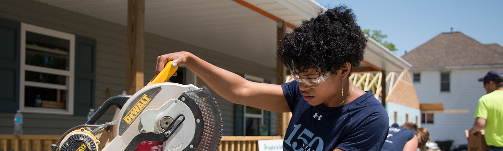 Busey Associates Habitat for Humanity with a woman using a circular saw