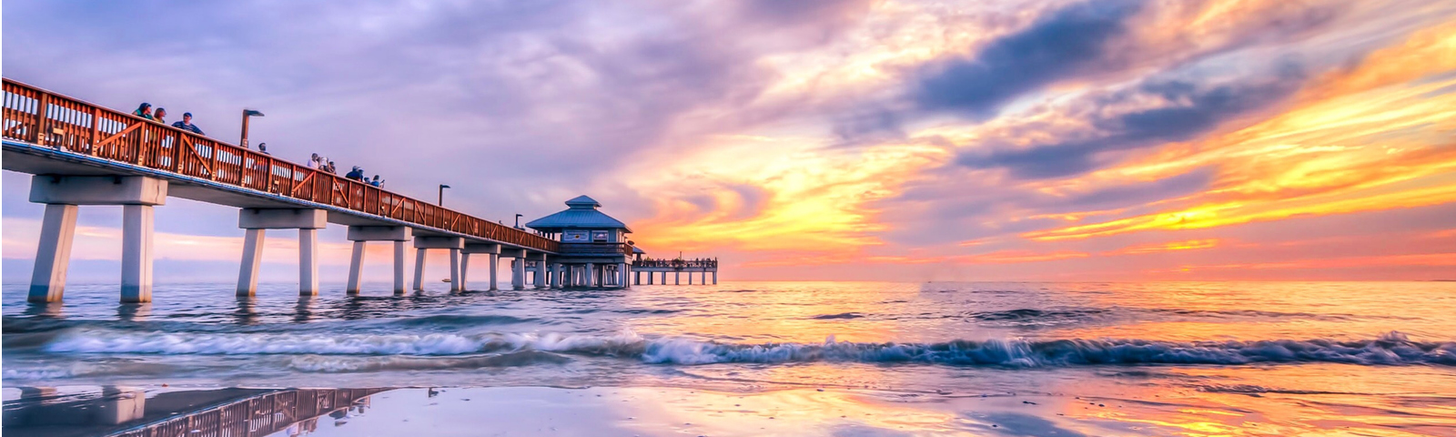 sunset over the ocean with a pier