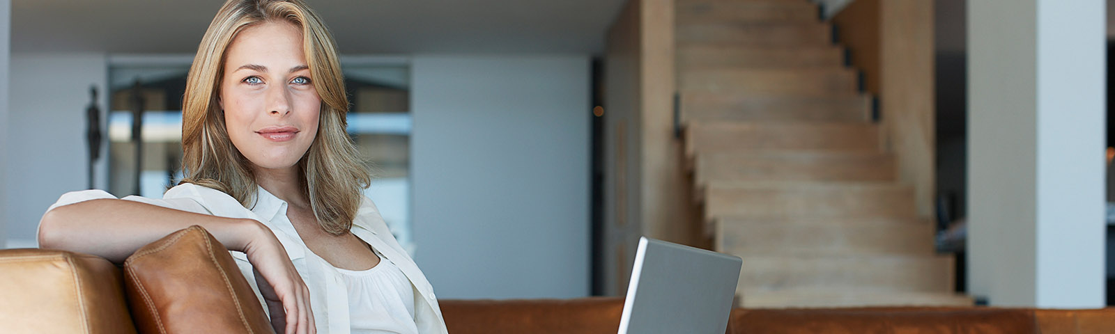 A woman sitting on a couch with her laptop