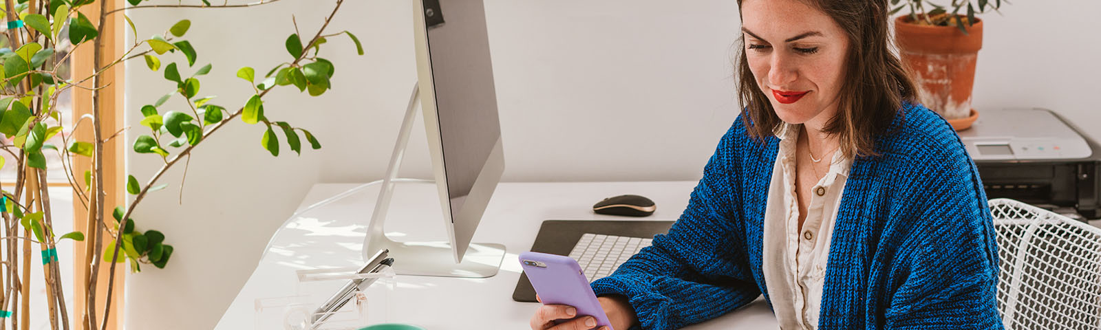 A woman looking down towards her phone in her hand