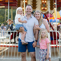 Busey associate Chad Tennill with his family in front of a Merry-Go-Round