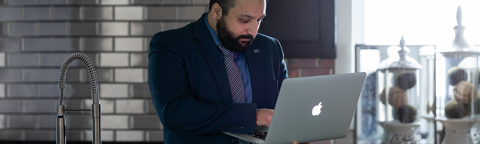 Man looking at laptop on a counter