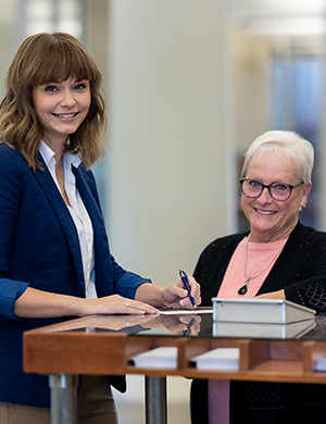 Busey Associates, Barb Humer and Emily Cross Vayr at a desk.