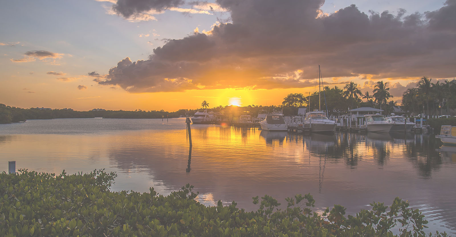The sun setting over a harbor.