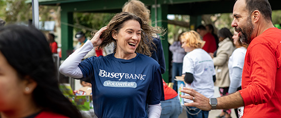 A woman with a Busey Bank Volunteer t-shirt in a crowd of people