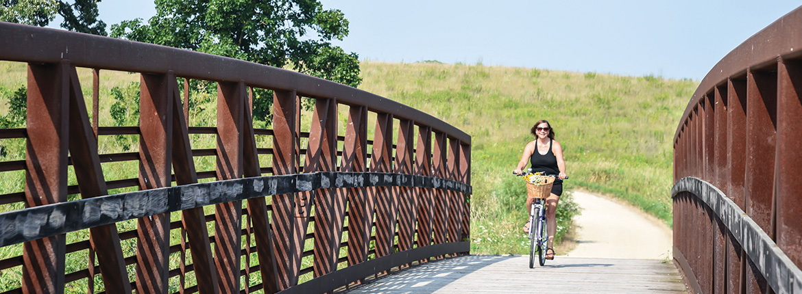 A woman on a bicycle riding on a bridge