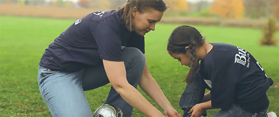 woman assisting a child with shoes
