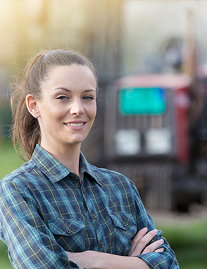 Farmer standing in front of a tractor.