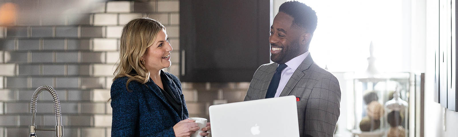 Woman and man talking with a laptop on a counter